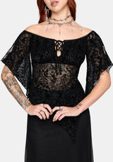 Woman wearing a black lace top with sheer sleeves on a white background