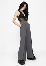 Woman wearing a black top and gray pants on a white background